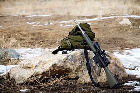 rifle with scope leaning up against a rock, backpack and box of ammunition Photographie de stock - Aubaine LD & Abonnement, Code: 400-03911629