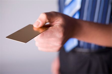 Man's hand holding gold credit card. Focus on the card. Body unfocus. Foto de stock - Super Valor sin royalties y Suscripción, Código: 400-03911848