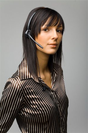 simsearch:400-03985399,k - Young woman with telephone headset, isolated on grey background in studio Foto de stock - Royalty-Free Super Valor e Assinatura, Número: 400-03911878