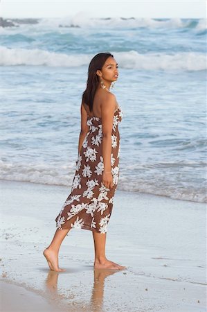 Ethnic model standing on the wet reflective sand at the beach Foto de stock - Super Valor sin royalties y Suscripción, Código: 400-03913899