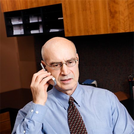 simsearch:400-03926822,k - Caucasian middle-aged businessman sitting in office talking on cellphone. Stock Photo - Budget Royalty-Free & Subscription, Code: 400-03924305