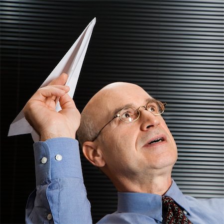 simsearch:400-03926822,k - Caucasian middle-aged businessman playing with paper airplane. Stock Photo - Budget Royalty-Free & Subscription, Code: 400-03924312