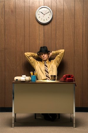 Caucasion mid-adult retro businessman wearing fedora sitting at desk leaning back with hands behind head. Stock Photo - Budget Royalty-Free & Subscription, Code: 400-03924425