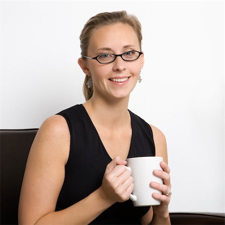 simsearch:400-03926822,k - Caucasian mid-adult woman wearing eyeglasses holding coffee cup and looking at viewer. Stock Photo - Budget Royalty-Free & Subscription, Code: 400-03924446