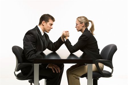 Side view of Caucasian mid-adult businessman and businesswoman arm wrestling on table. Stock Photo - Budget Royalty-Free & Subscription, Code: 400-03924456