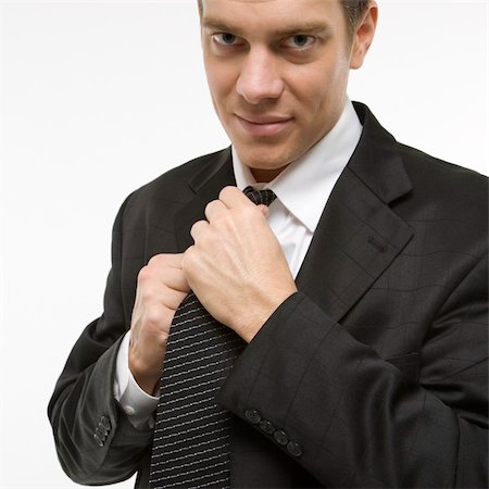 raddrizzare - Caucasian mid-adult man straightening necktie. Fotografie stock - Microstock e Abbonamento, Codice: 400-03924483