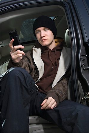 Caucasian male teenager sitting in car looking at cellphone. Stock Photo - Budget Royalty-Free & Subscription, Code: 400-03924674