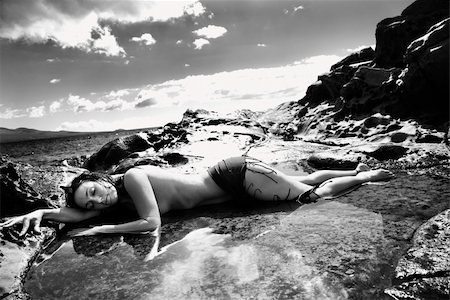 simsearch:400-04956611,k - Nude Caucasian mid adult woman lying in tidal pool at Maui coast with eyes closed and head on arm. Photographie de stock - Aubaine LD & Abonnement, Code: 400-03925143