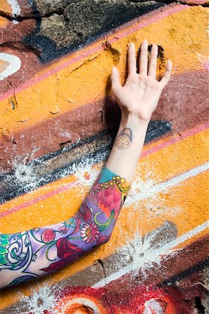 simsearch:400-04186416,k - Tattooed Caucasian woman's arm against graffiti covered wall. Stockbilder - Microstock & Abonnement, Bildnummer: 400-03925206