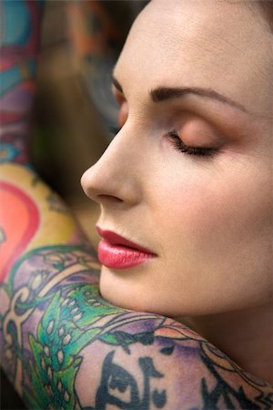 simsearch:400-04186416,k - Close-up portrait of attractive woman's face and tattooed arm. Stockbilder - Microstock & Abonnement, Bildnummer: 400-03925217