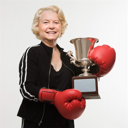 Caucasian senior woman wearing boxing gloves holding trophy. Stock Photo - Budget Royalty-Free & Subscription, Code: 400-03925633