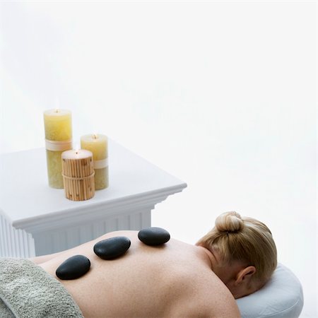 simsearch:400-04956215,k - Caucasian middle-aged woman lying on massage table with hot stones on her back. Photographie de stock - Aubaine LD & Abonnement, Code: 400-03925697