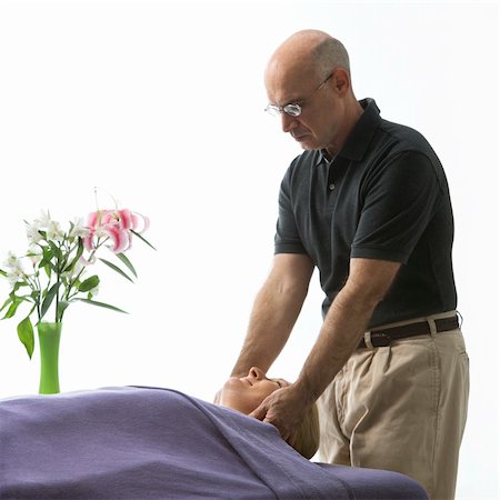 simsearch:400-04956215,k - Caucasian middle-aged male massage therapist massaging face of Caucasian middle-aged woman lying on massage table. Photographie de stock - Aubaine LD & Abonnement, Code: 400-03925690