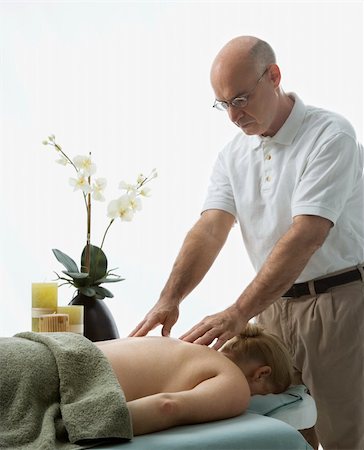 simsearch:400-04956215,k - Caucasian middle-aged male massage therapist massaging back of Caucasian middle-aged woman lying on massage table. Photographie de stock - Aubaine LD & Abonnement, Code: 400-03925693