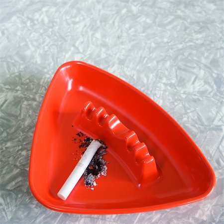simsearch:700-02757138,k - Still life of red plastic vintage ashtray containing cigarette butt and ashes. Stock Photo - Budget Royalty-Free & Subscription, Code: 400-03925752