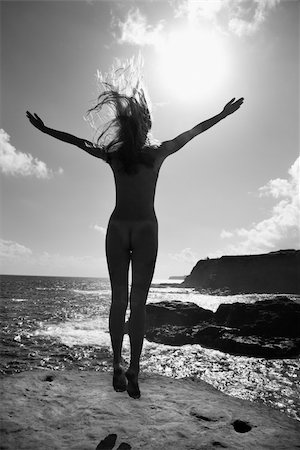 simsearch:400-04450908,k - Back view of young nude Asian woman jumping into the air facing the ocean. Stock Photo - Budget Royalty-Free & Subscription, Code: 400-03925892