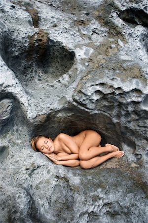 simsearch:400-04956611,k - Young Asian nude woman sleeping in a crevice in a rock. Photographie de stock - Aubaine LD & Abonnement, Code: 400-03925908