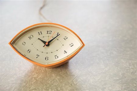 simsearch:700-03161591,k - Still life of orange eye-shaped vintage clock on table. Stock Photo - Budget Royalty-Free & Subscription, Code: 400-03926012