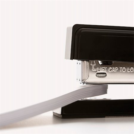 simsearch:400-03926061,k - Close up of black stapler on white background stapling paper. Foto de stock - Royalty-Free Super Valor e Assinatura, Número: 400-03926033