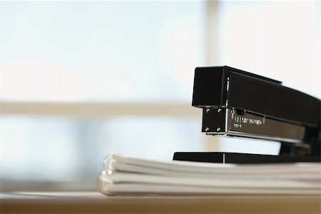 simsearch:400-03926032,k - Black stapler on stack of paper with window in background. Stock Photo - Budget Royalty-Free & Subscription, Code: 400-03926069