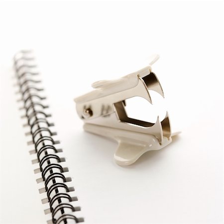 simsearch:400-03926061,k - Staple remover on top of an open spiral bound notebook. Foto de stock - Royalty-Free Super Valor e Assinatura, Número: 400-03926088
