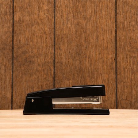 simsearch:400-03926032,k - Black stapler on desk with wooden paneling. Stock Photo - Budget Royalty-Free & Subscription, Code: 400-03926118