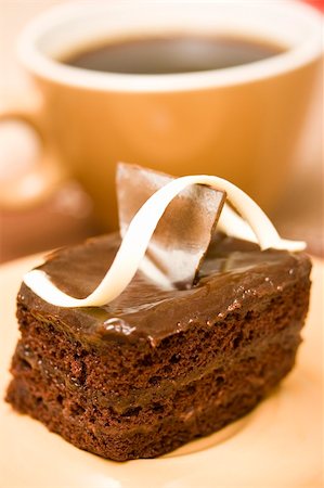 simsearch:400-03969594,k - A sliced cake with coffee in the background. Photographie de stock - Aubaine LD & Abonnement, Code: 400-03926188