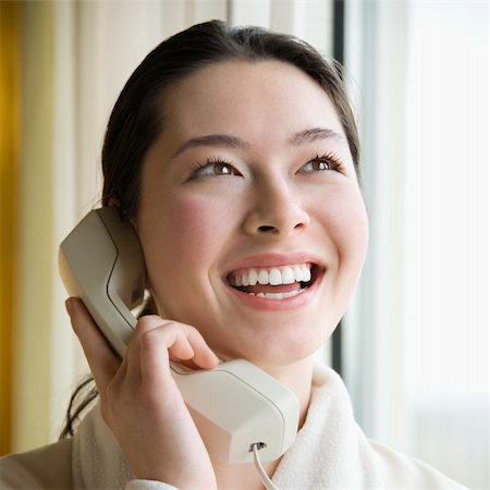 simsearch:400-03926201,k - Taiwanese mid adult woman in bathrobe talking on phone and smiling. Fotografie stock - Microstock e Abbonamento, Codice: 400-03926200