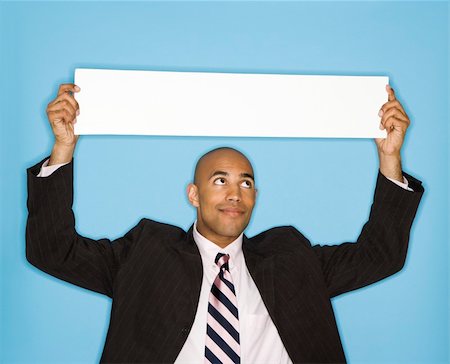 endorsing - African American man holding blank sign against blue background. Stock Photo - Budget Royalty-Free & Subscription, Code: 400-03926236