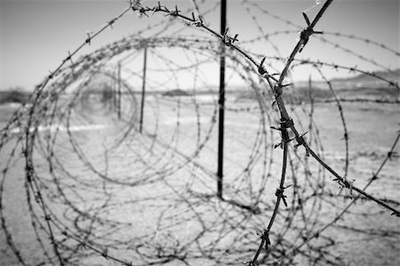 profugo (uomo e donna) - barbed wire at the border of a mine field Fotografie stock - Microstock e Abbonamento, Codice: 400-03926331