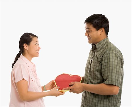 simsearch:400-03968461,k - Asian man giving Asian woman a heart shaped box. Photographie de stock - Aubaine LD & Abonnement, Code: 400-03926490