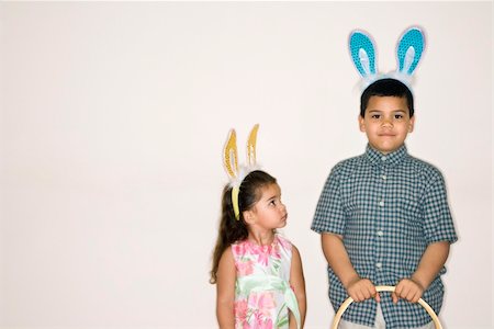 simsearch:400-04452450,k - Hispanic girl looking up at Hispanic boy holding Easter basket both wearing bunny ears. Stock Photo - Budget Royalty-Free & Subscription, Code: 400-03926561