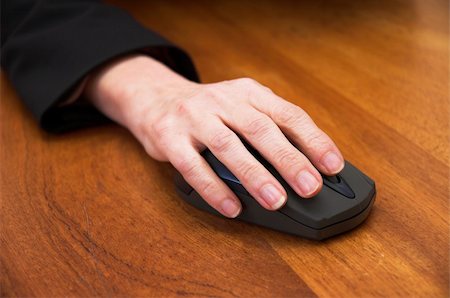 Woman's hand using a wireless computer mouse. Focus is on the front of the mouse / end of the fingers. Stock Photo - Budget Royalty-Free & Subscription, Code: 400-03926705