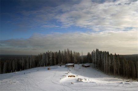 simsearch:400-03938269,k - Solar winter day. The small house on a hill in an environment of a pine wood. On a snow before the house traces from skis Foto de stock - Super Valor sin royalties y Suscripción, Código: 400-03927512