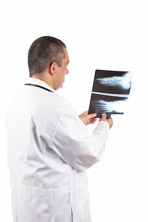 Friendly male doctor in lab coat, examining x-ray against white background Stock Photo - Budget Royalty-Free & Subscription, Code: 400-03927846