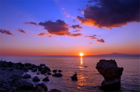 simsearch:400-03925229,k - Image shows a sunset over the Messinian bay, Greece, with a rocky seascape in the foreground Stock Photo - Budget Royalty-Free & Subscription, Code: 400-03928266