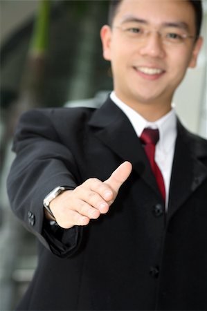 Good looking asian business man standing with arms outstretched ready to shake hands. Stock Photo - Budget Royalty-Free & Subscription, Code: 400-03928604