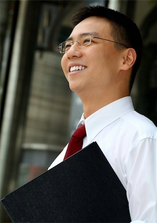 simsearch:6109-06002735,k - Good looking asian business man smiling with folder in hand. Stock Photo - Budget Royalty-Free & Subscription, Code: 400-03928898
