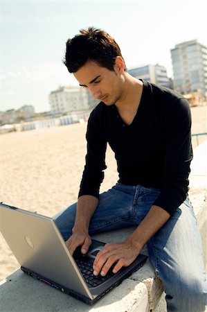 Young man using a personal computer while sitting outdoor Stock Photo - Budget Royalty-Free & Subscription, Code: 400-03929106