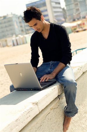 Young cool handsome man uses a personal computer sitting outdoor Stock Photo - Budget Royalty-Free & Subscription, Code: 400-03929107