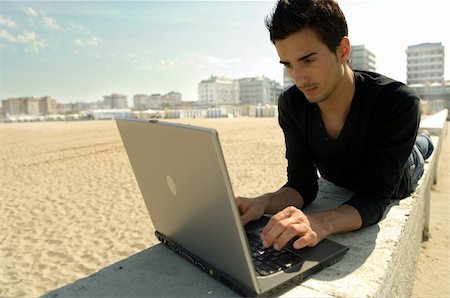 single landscape - Attractive cool young man at the beach works with a notebook Photographie de stock - Aubaine LD & Abonnement, Code: 400-03929108