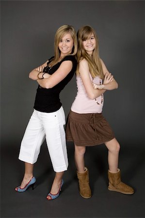 simsearch:400-04960190,k - Teenage sisters posing on gray background with some attitude Stock Photo - Budget Royalty-Free & Subscription, Code: 400-03929630