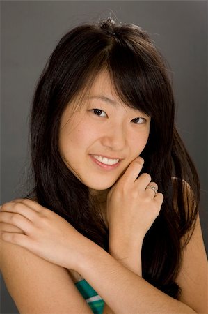 simsearch:400-04960190,k - Portrait of a beautiful Asian teenager posing on a gray background with some attitude Stock Photo - Budget Royalty-Free & Subscription, Code: 400-03929808