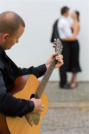 people in italy playing music - A street musician playing his guitar serenades two young lovers Stock Photo - Budget Royalty-Free & Subscription, Code: 400-03929827