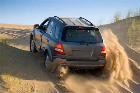 dune driving - A four-wheel-drive drives through the sand dunes. Foto de stock - Super Valor sin royalties y Suscripción, Código: 400-03920262