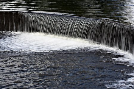 Water flowing over a manmade dam in a lake Foto de stock - Super Valor sin royalties y Suscripción, Código: 400-03920389