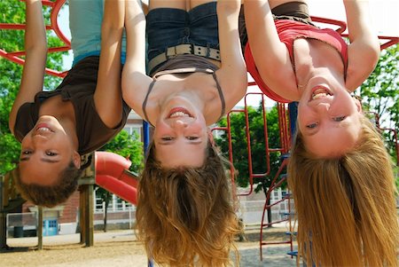 Three young girls hanging upside down in a park and laughing Stock Photo - Budget Royalty-Free & Subscription, Code: 400-03920403