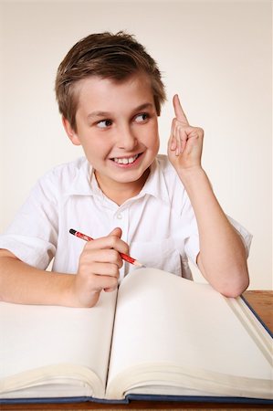 simsearch:614-02762668,k - Student school boy sitting at desk with school books has an inspirational idea Photographie de stock - Aubaine LD & Abonnement, Code: 400-03920435