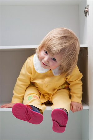 simsearch:400-04436228,k - cute little girl is sitting in the cupboard Stock Photo - Budget Royalty-Free & Subscription, Code: 400-03920549
