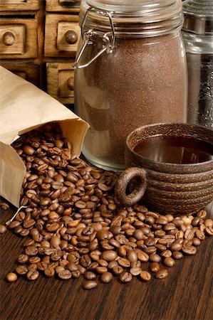 simsearch:659-08904383,k - Image of roasted coffee beans, coffee cup, and ground beans on a wooden table. Fotografie stock - Microstock e Abbonamento, Codice: 400-03920640